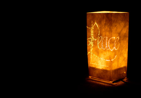 Christmas ornament with candles spelling peace light up decoration in darknessの写真素材