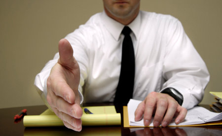 Business man sitting at desk holding pen with filesの写真素材