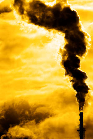 Pollution rising from factory smoke smokestack chimney environmentの写真素材