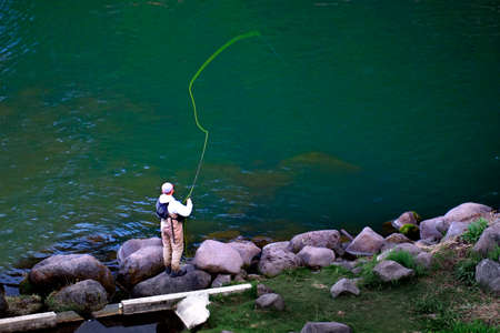 Person fishing in stream or river in wilderness for sportの写真素材