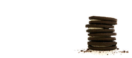 Chocolate cookies with creme filling and crumbs on white background panorama styleの写真素材