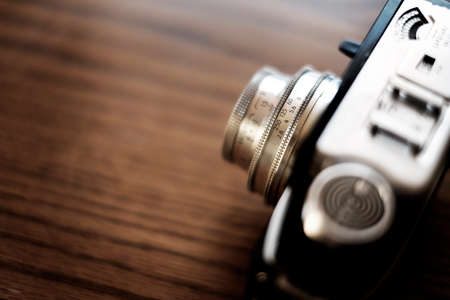 Detail of old worn vintage film camera closeup on wooden surfaceの写真素材
