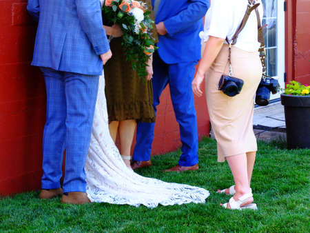 Wedding couple bride and groom with photographer taking photosの写真素材