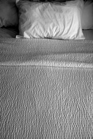 Clean bed bedding and pillows with white sheets for comfort sleeping