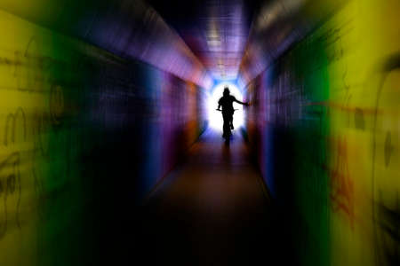 Riding bike bicycle through tunnel with graffiti innercity zoom effect motionの写真素材