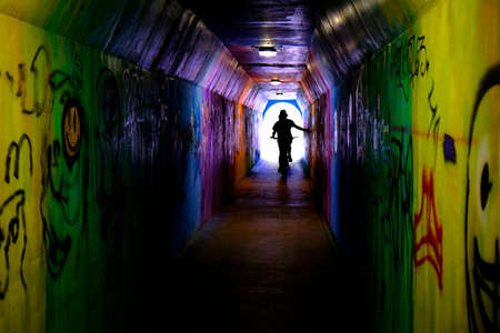 Riding bike bicycle through tunnel with graffiti innercityの写真素材