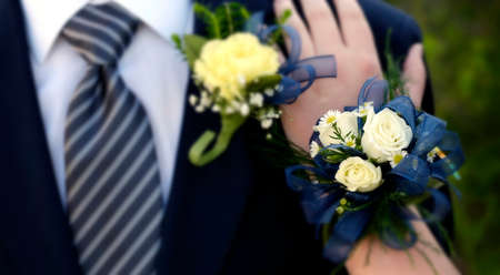 Hands of date Prom night flowers corsage formal wear hand on shoulder selective focus blurの写真素材