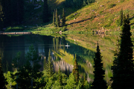 Person standing paddle boarding on high mountain lakeの写真素材