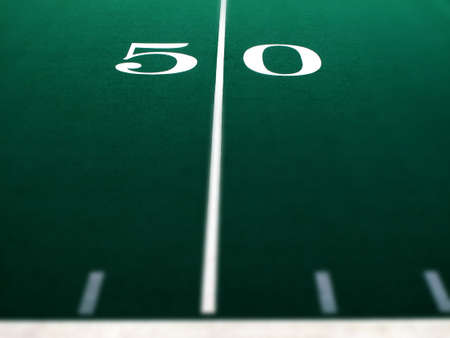 Football field for sports and achievement 50 yard marker selective focus blurの写真素材