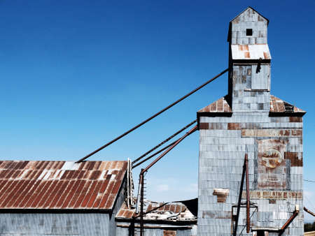 Old abandoned granary with painted signs and blue skyの写真素材