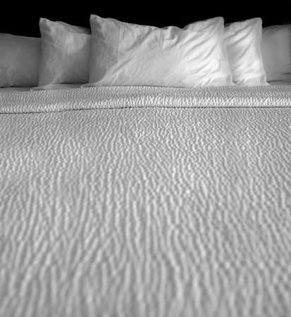 Clean bed bedding and pillows with white sheets for comfort sleeping textureの写真素材