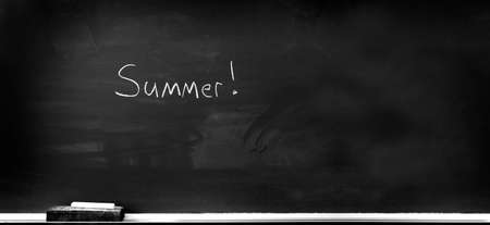 Chalkboard in school for education with eraser and chalk writing summer vacation summertimeの写真素材