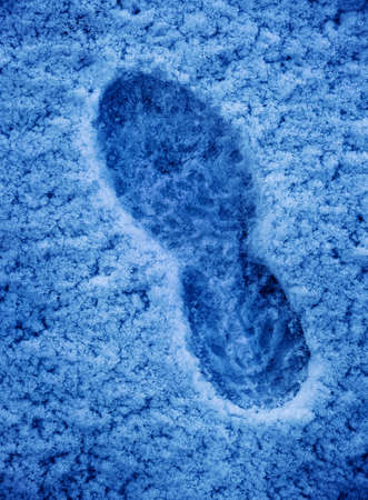 Footprint or bootprint in fresh snow cold track walking in winter icy adventureの写真素材