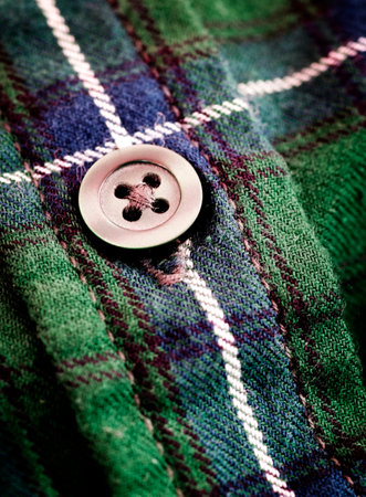 Closeup of button on green plaid flannel shirt worn for fashion and warmth in Fall or Winterの写真素材