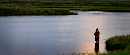 Flyfisherman fly fisherman fishing on river with Tetons in Backgroundの写真素材