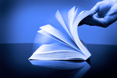 Book for reading and hand flipping pages looking at informationの写真素材