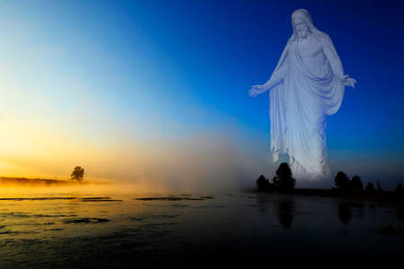 Morning sunrise with trees and river under blue sky and glowing mist with Jesus as the Creatorの写真素材
