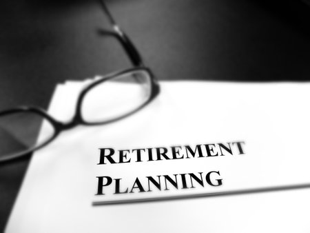 Retirement planning documents on desk with glasses for plan to retire blur and focusの写真素材