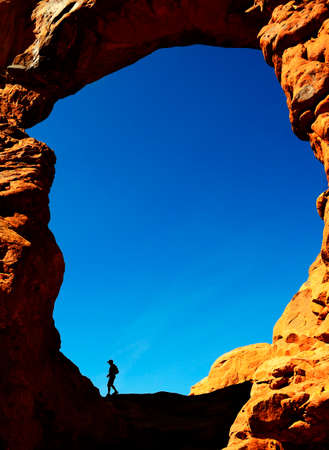 Silhouette of hiker in Turret Arch canyon rock formations Arches National Parkの写真素材