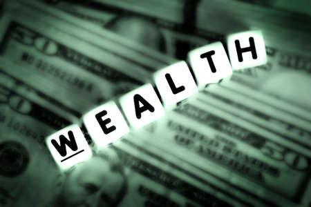 Wealthy spelled out in block letters dice representing rich investments wealthyの写真素材