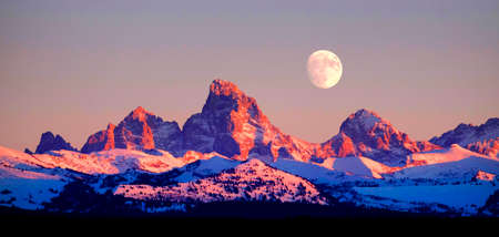 Sunset light with alpen glow on Tetons Tetons mountains rugged with moon risingの写真素材