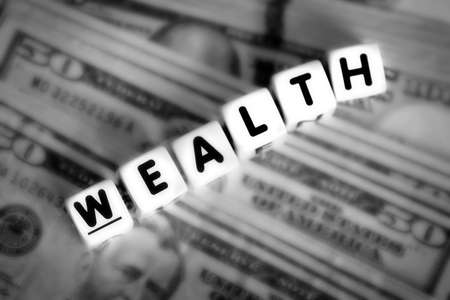 Wealthy spelled out in block letters dice representing rich investments wealthyの写真素材
