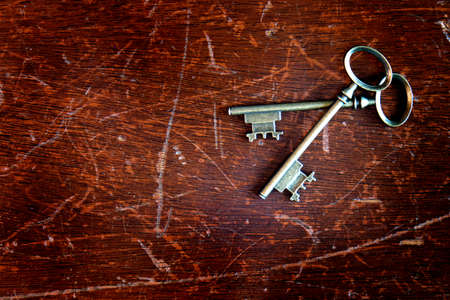 Old antique keys on worn wood texture backgroundの写真素材
