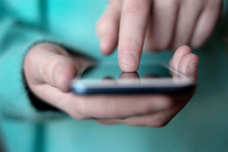Finger on a smart phone exploring dataの写真素材