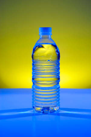 Water bottle holding a cool refreshing drink blue and yellow lightの写真素材