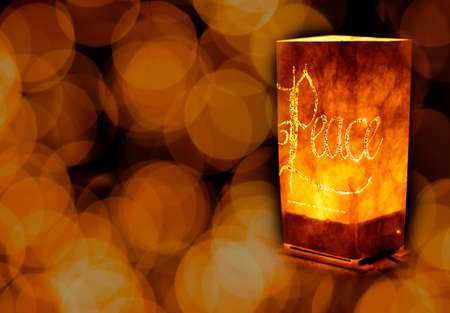 Christmas ornament with candles spelling peace light up decoration in darkness lights focusの写真素材