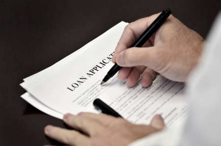 Document loan or contract on a desk with a black penの写真素材