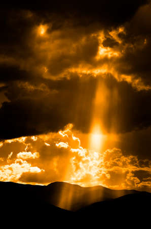 Sun rays in clouds with mountains