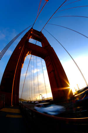 Golden Gate Bridge in San Francisco at evening with sunlight and traffic drivingの写真素材
