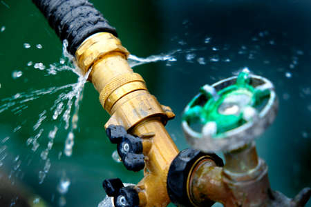 Closeup of leaky faucet spraying water leak drops dripsの写真素材