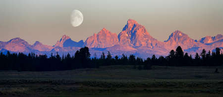 Detail of sun setting last light on Teton Mountain Range Tetons with river and moonの写真素材
