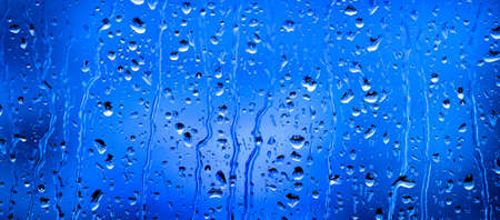 Window with rain or water drops from stormy weatherの写真素材