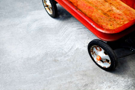 Red wagon on sidewalk for children and kids to play with in summer