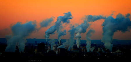 Factory smoke rising in air pollution at sunrise of sunsetの写真素材