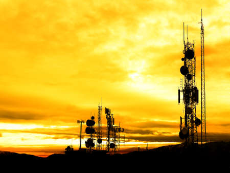 Radio communication towers for broadcasting television internet and communications at sunrise or sunset silhouetteの写真素材