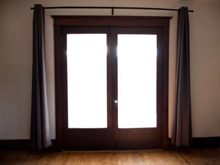 Entrance to home glass doors with drapes and bright light entering houseの写真素材