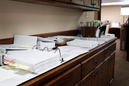 Binders on desk or shelves in an office for organizing business documentsの写真素材