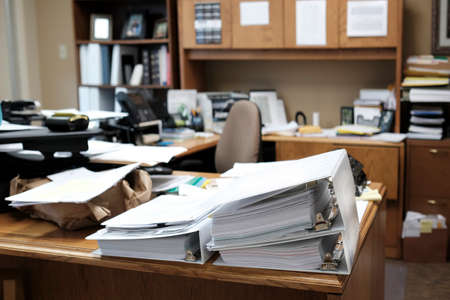 Binders on desk or shelves in an office for organizing business documents