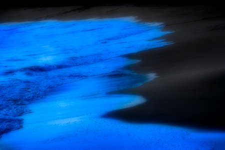 Misty and dreamy bright blue waves on a beach from ocean swell water clean and freshの写真素材