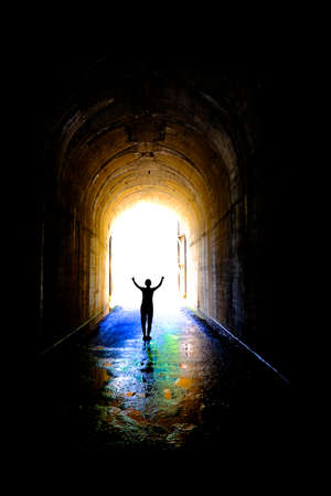 Single individual person at end of tunnel for success and triumph at end of journeyの写真素材