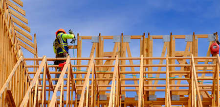 Construction workers working on new home or restidential building with wooden beams framed and skyの写真素材