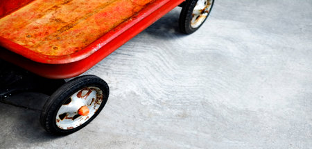 Red wagon on sidewalk for children and kids to play with in summerの写真素材