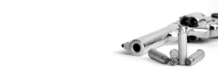 Closeup of powerful handgun with bullets on white  surface