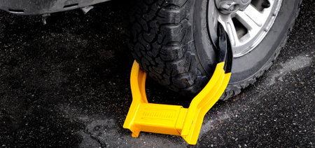 Wheet boot or tire lock on a vehicle or car for illegal parking violationの写真素材