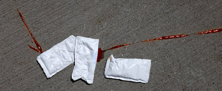 Squished ketchup catsup packet of sidewalkの写真素材