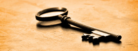 Old key laying on top of worn woodの写真素材